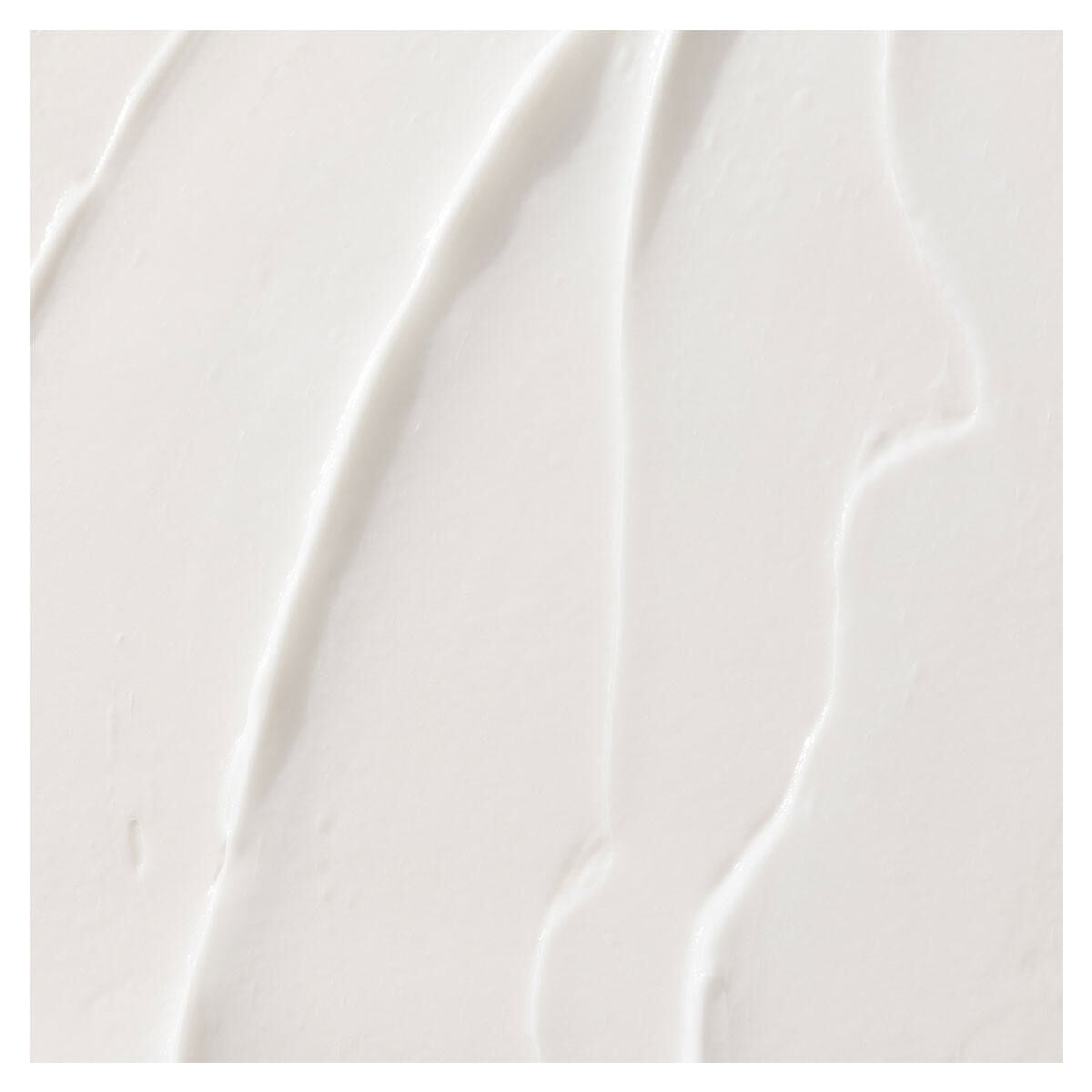 White conditioner bottle with curved ridged texture and minimalist design, shot at an angle against neutral background.